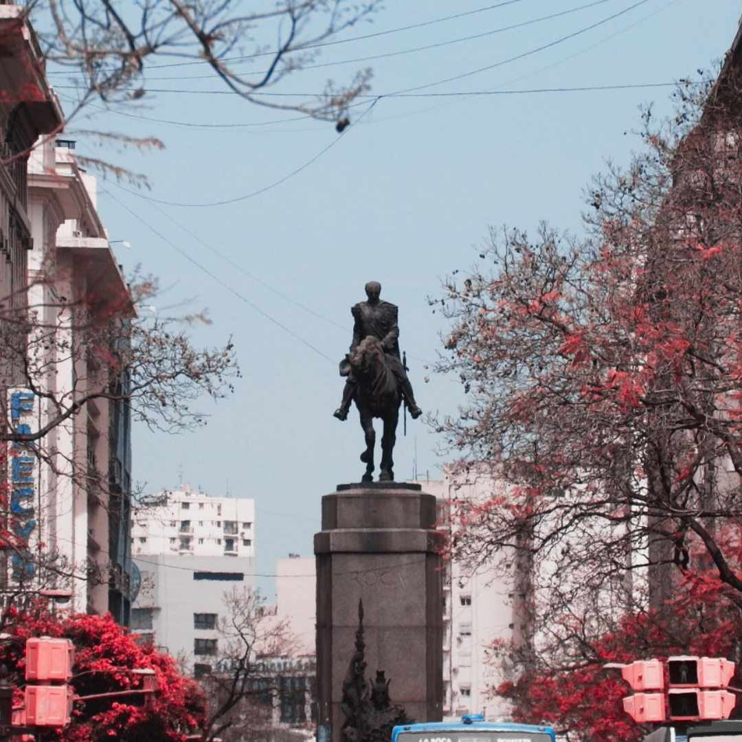 The equestrian statue of General Julio Roca, with office buildings behind it, and a street full of people in front.