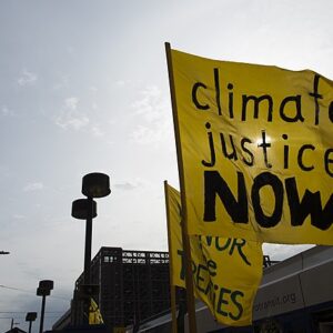 Yellow flag with Climate Justice Now written