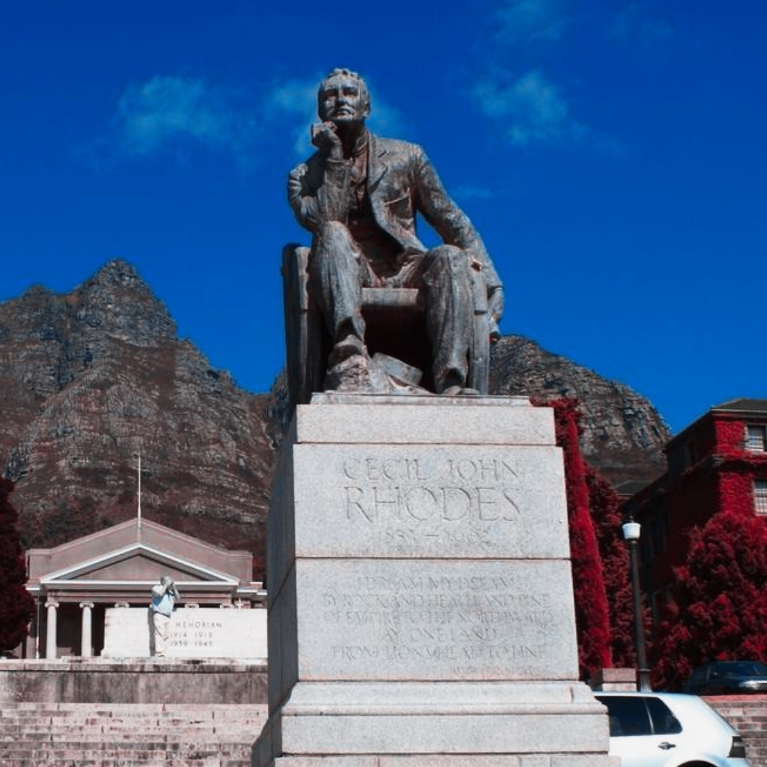 Statue of Cecil Rhodes sitting locaded on steps of the Univerity of Cape Town campus.