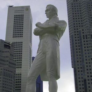A statue of Sir Stamford Raffles in Singapore, with skyscrapers rising in the background.